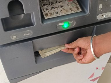 ATM 'den para çekme - ATM' de Hint rupileri. Adam ATM, otomatik vezne makinesi konseptiyle para çekiyor.