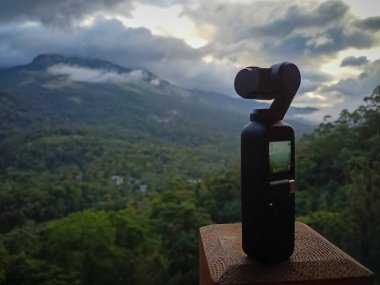 Munnar, Hindistan - 16 Nisan 2022: DJI Osmo Pocket kamera geçen bulutların hızlandırılmış videosunu çekiyor - hareket kamerası tripod olmadan çalışıyor.