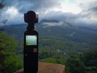Munnar, Hindistan - 16 Nisan 2022: DJI Osmo Pocket kamera geçen bulutların hızlandırılmış videosunu çekiyor - hareket kamerası tripod olmadan çalışıyor.