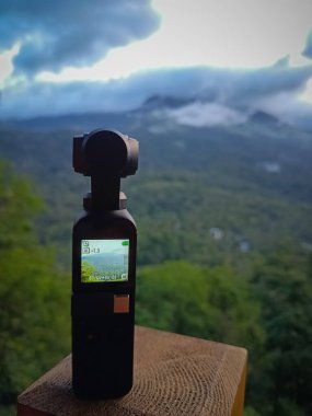 Munnar, Hindistan - 16 Nisan 2022: DJI Osmo Pocket kamera geçen bulutların hızlandırılmış videosunu çekiyor - hareket kamerası tripod olmadan çalışıyor.