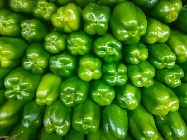 Fresh green bell pepper (capsicum) on market with Vegetable background. Selling Green Capsicum in local market.