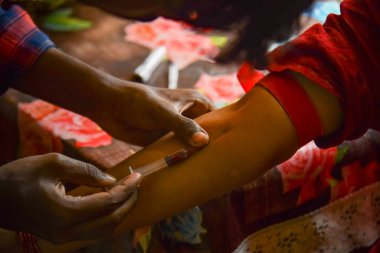 Closeup view of doctor's hands taking a blood sample from pregnant lady. swab is pressed onto the injection site during the blood collection.