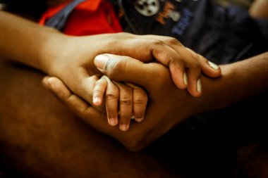 Parenthood Concept - Happy Mom and Dad are holding Baby Finger on hands. Parents are holding the hand and finger of a newborn baby