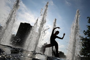 Fıskiyelerin arka planında bir kız silueti. Dans yaşam tarzı