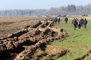Islak zeminde traktör izleri var. Hasarlı tarlalar çiftçilerin ektiği