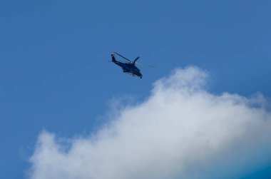 Mavi gökyüzü arkaplanına karşı helikopter silueti