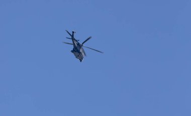 Mavi gökyüzü arkaplanına karşı helikopter silueti