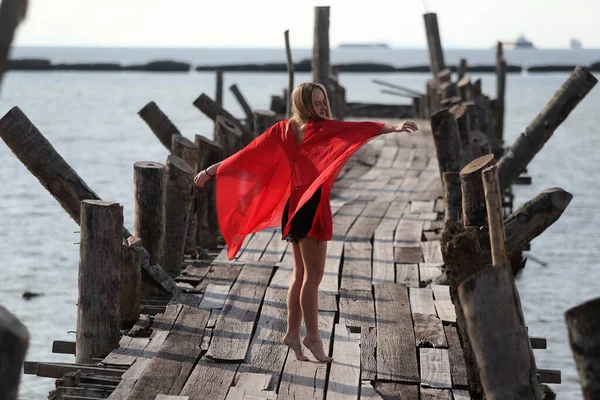 Ein Schönes Mädchen Rot Posiert Auf Einer Holzbrücke Meer Das — Stockfoto