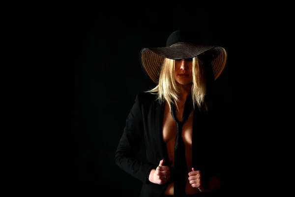 暗い背景に大きな黒い帽子で美しい女性 ロイヤリティフリーのストック画像
