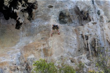 Dağcılar Krabi, Tayland 'daki Beach Bay' de kaya tırmanışı yapıyorlar.