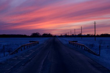 Güzel renkli günbatımı kış manzarası Köye giden bir yol