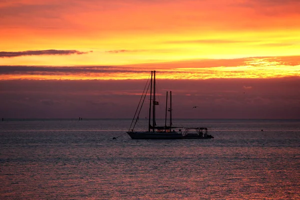 Dramatic tropical Florida sunset with yacht silhouette