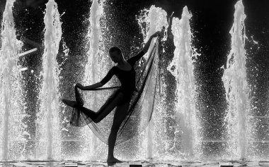 Fıskiyelerin arka planında bir kız silueti. Dans yaşam tarzı