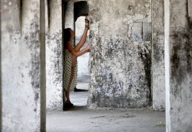 A flexible young woman performing a vertical split in an abandoned fort