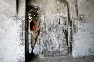 A flexible young woman performing a vertical split in an abandoned fort