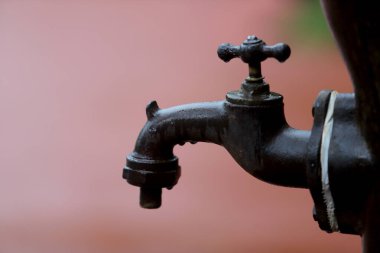 Pembe arka planda eski bir musluk