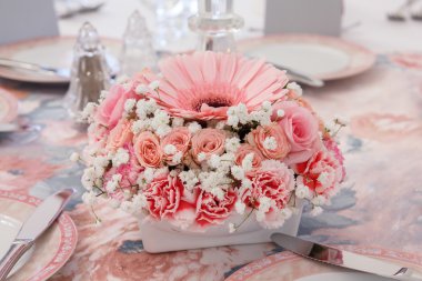 Tablo üzerinde pembe çiçek aranjmanı