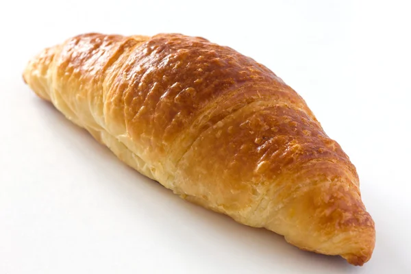 Single croissant on white surface — Stock Photo, Image