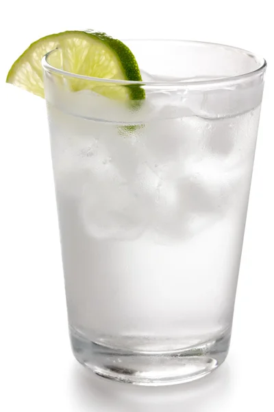 Glass of water with floating ice cubes and lime slice — Stock Photo, Image