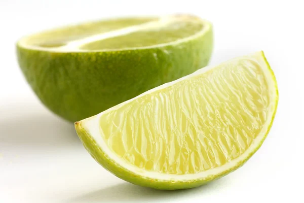 Limoen gerangschikt op een wit oppervlak — Stockfoto