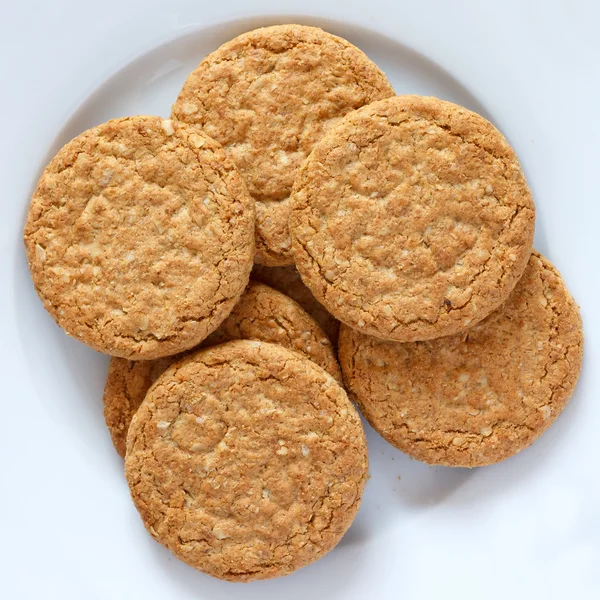 Plate of crispy golden oat biscuits — Stock Photo, Image