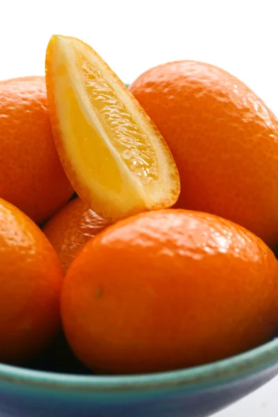 Baby oranges arranged in a blue pottery bowl — Stock Photo, Image