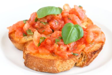 Klasik İtalyan bruschetta domates ve fesleğen kızarmış ekmek üzerinde.