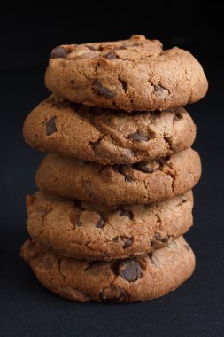 çikolatalı kurabiye koyu gri kumaş üzerine yığını.