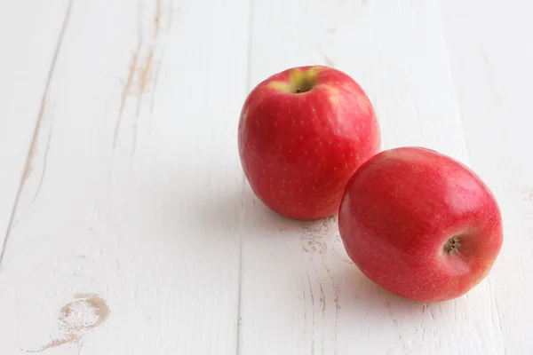 Manzanas de señora rosa sobre una mesa de madera rústica blanca pintada . — Foto de Stock