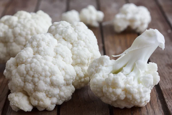 Flores frescas de coliflor en un tablero de madera oscura . — Foto de Stock