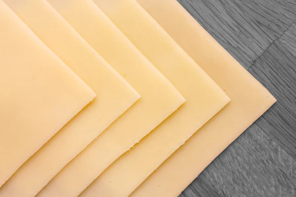 Fromage jaune tranché bien disposé sur une surface en bois. Tourné d'en haut . — Photo