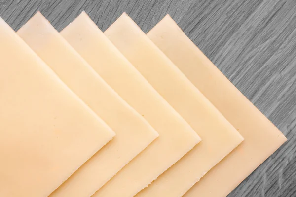 Fetta di sabbia gialla che formaggio ordinatamente disposti su una superficie di legno. Colpito dall'alto . — Foto Stock