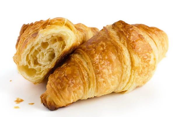 Dos croissants en una superficie blanca con uno roto . —  Fotos de Stock