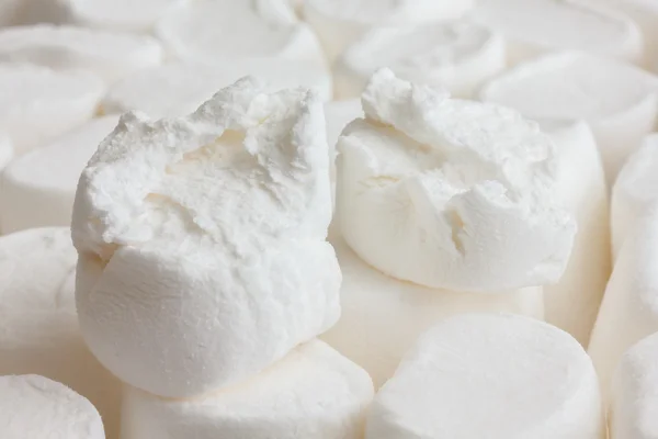 Único marshmallow branco rasgado em dois sentado em outros marshmallows . — Fotografia de Stock