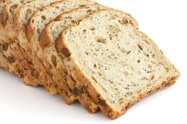 Slices of multi-seed whole-wheat bread on white surface — Stock Photo, Image
