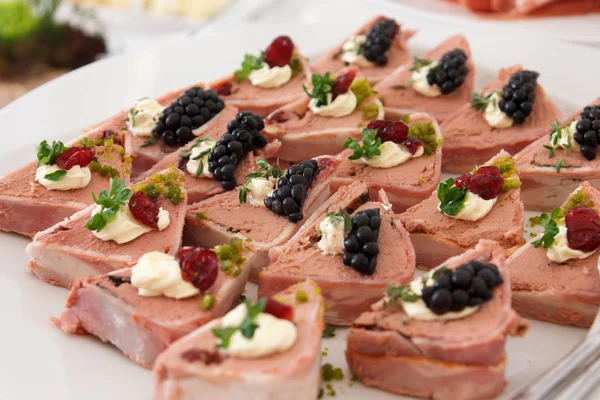 Garnished with blackberries pate wrapped in bacon on white plate. — Stock Photo, Image