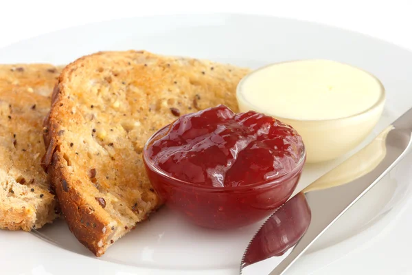 Rebanada de pan integral multisemilla tostado con mantequilla y mermelada —  Fotos de Stock