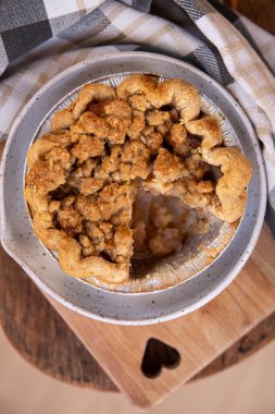 Kalp şeklinde kesme tahtasının üzerinde ev yapımı küçük elmalı turta.