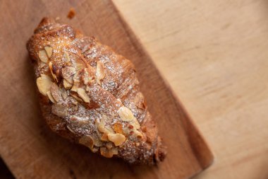 Kesme tahtasındaki badem kruvasanı.