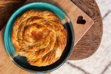 Yukardan bir tabakta meyve dolu Danimarka Pastası ile kalp kesme tahtası