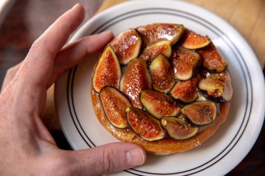 Hand grabbing a fig tart