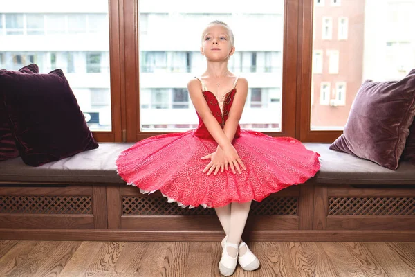 プロのバレエダンサー 古典舞踊学校になることを夢見て笑顔の赤ちゃんの女の子 小さなバレリーナは窓の前に座って — ストック写真