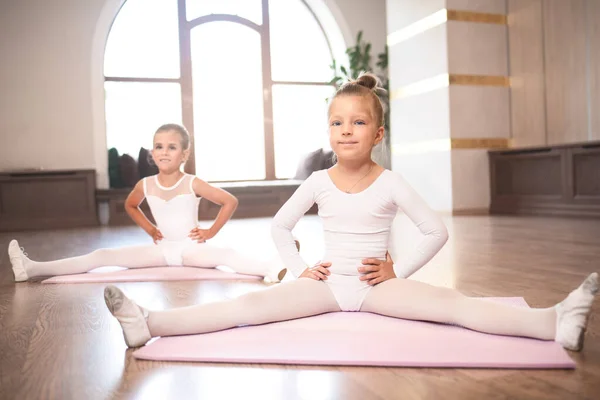 二人の美しい赤ちゃん女の子作る足ストレッチ床に座っている間バレエダンス振付クラス — ストック写真