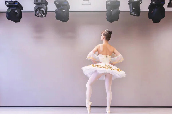 白鳥のプロチュチュのスカートの中で若い白人バレエダンサーの練習バレエの位置のバックビュー 訓練後リラックスしたチュチュの若い美しい女性バレエダンサー — ストック写真