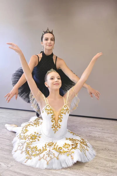振付師先生メンタートレーナーの古典舞踊教室では 若い学生にストレッチと姿勢のヘルプを教えていますダンスティーン女の子バレリーナ — ストック写真