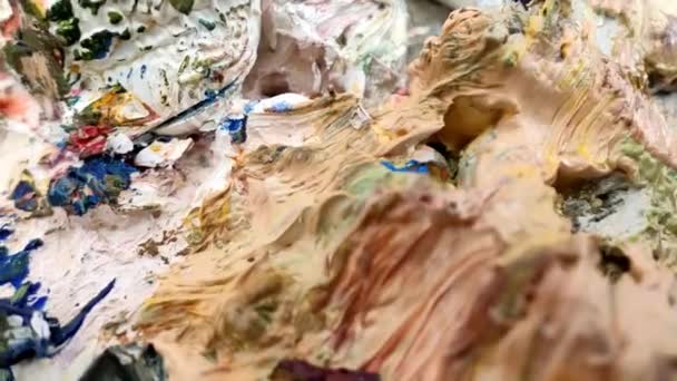 Художник смешивает масляные краски на палитре — стоковое видео