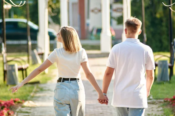Ein liebevoller Kerl und ein Mädchen gehen in der Natur spazieren. Liebhaber, die im Park spazieren gehen. Lovestory-Konzept im Freien. — Stockfoto