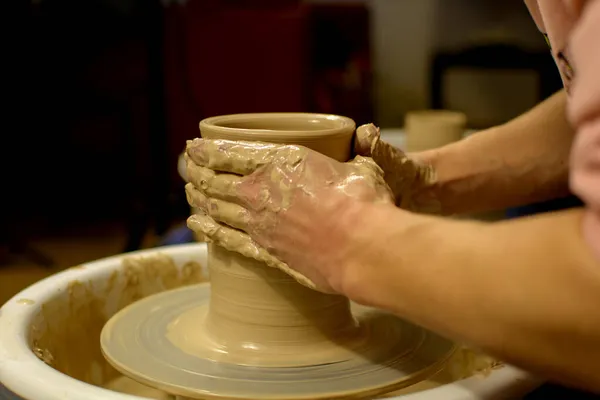 La femme potiers mains formées par un pot d'argile sur une roue de potiers. Le potier travaille dans un atelier — Photo