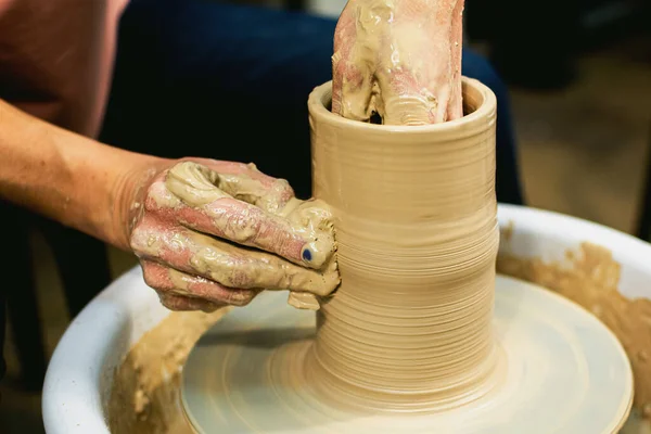 La femme potiers mains formées par un pot d'argile sur une roue de potiers. Le potier travaille dans un atelier — Photo