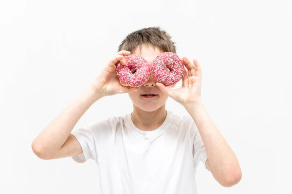 Portret van een jongen met een donut op zijn gezicht — Stockfoto